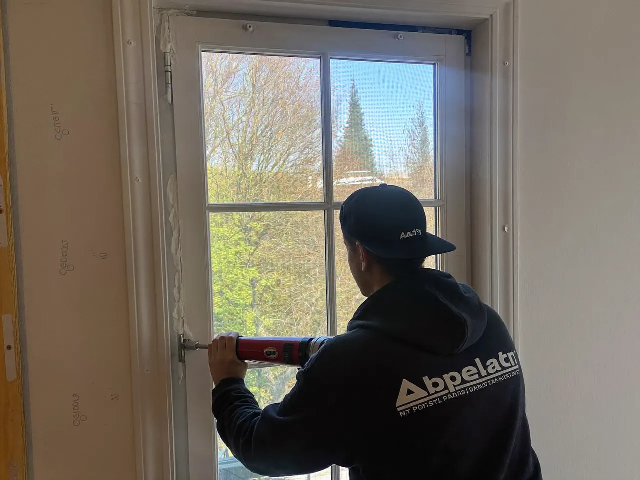 An installer sealing the frame of a newly fitted window