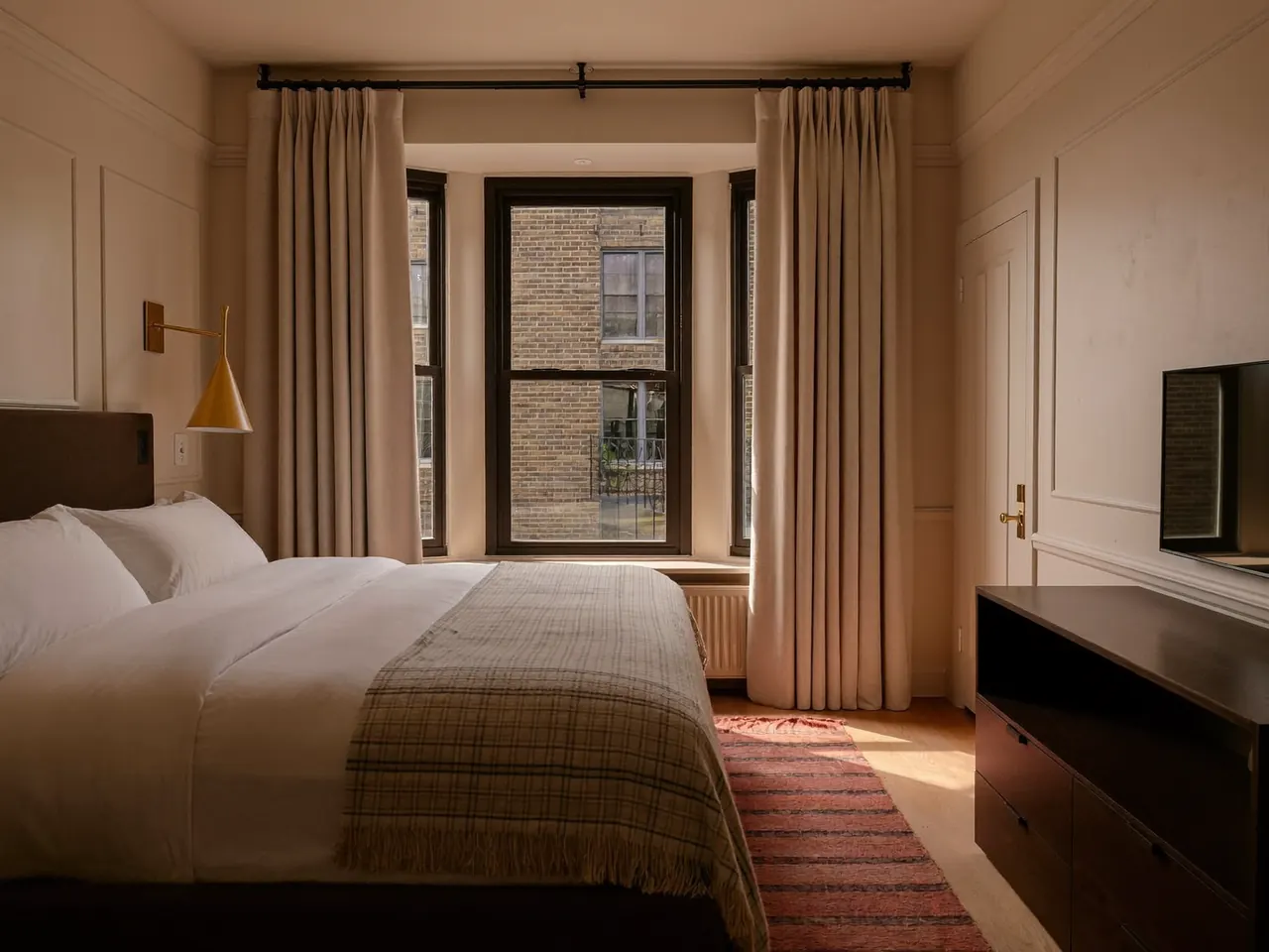 A warm bedroom in soft morning light beside a new insulated window